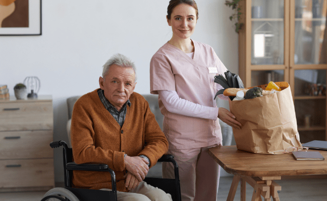 Photo of a caregiver with groceries delivered to the senior